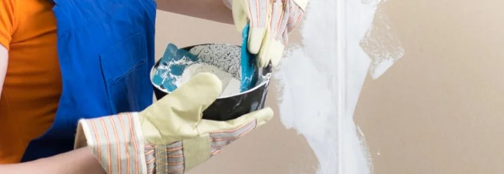 Person trägt Spachtelmasse auf